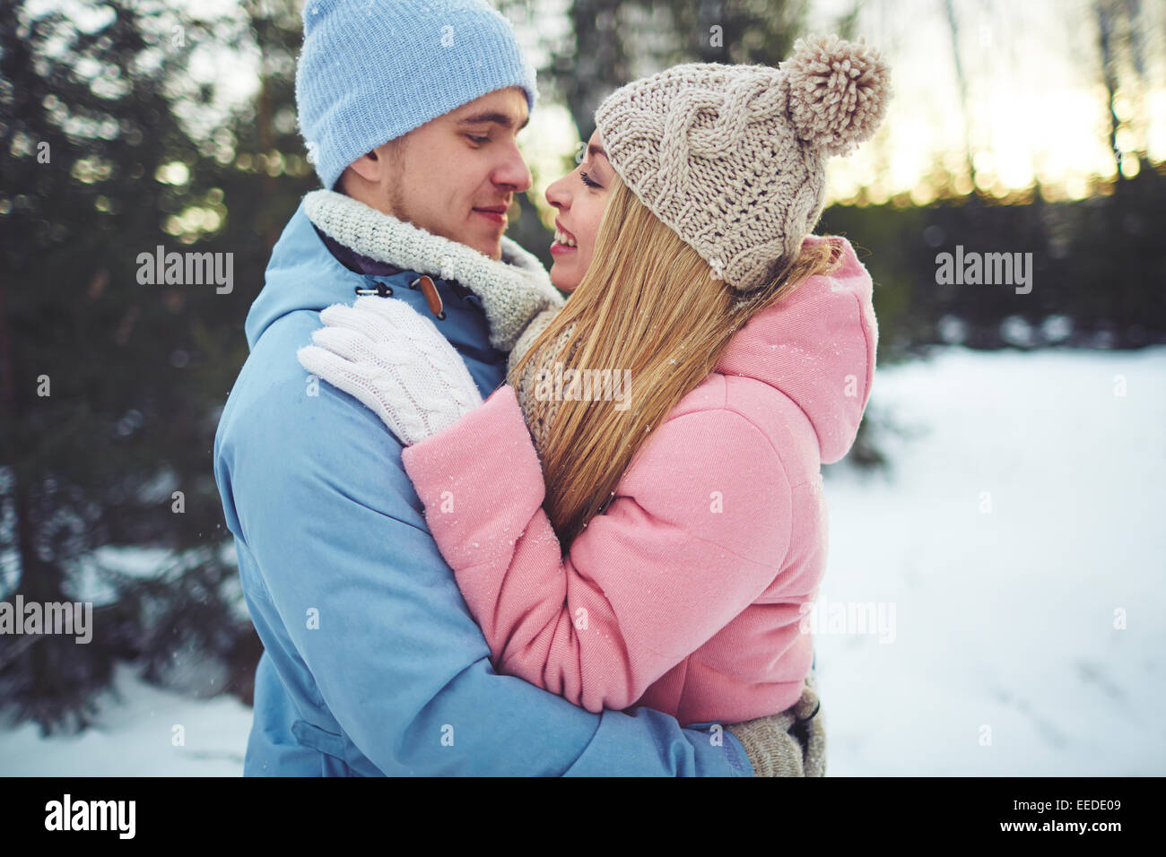 Verliebten Paar in Umarmung betrachten einander im park Stockfoto