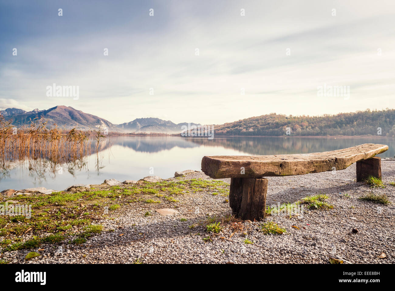 Eine wunderschöne Seenlandschaft mit einer Holzbank im Vordergrund Stockfoto