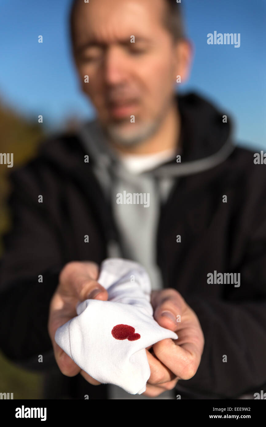 Kaukasischen Mann hält eine blutige Gewebe Stockfoto