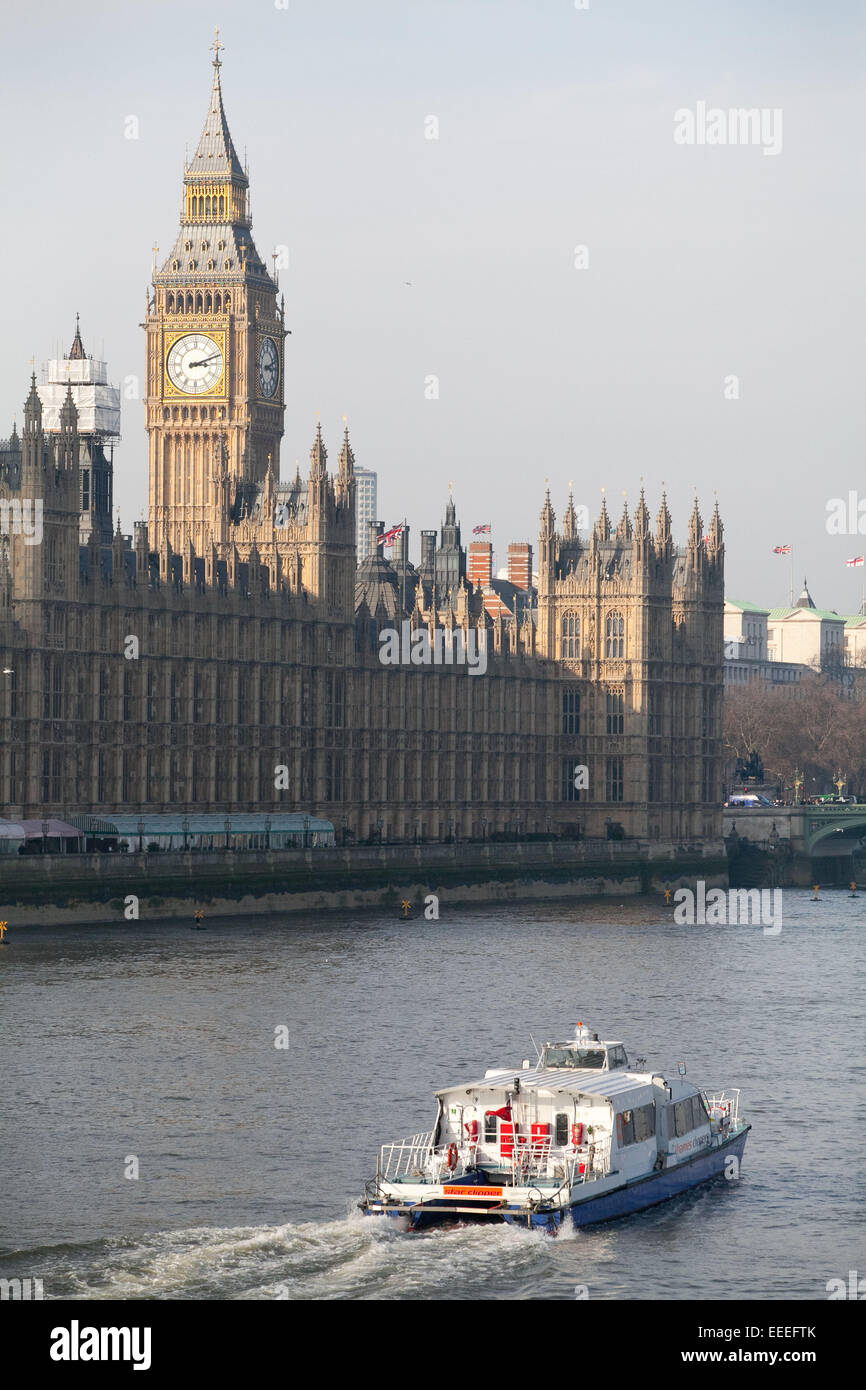 Ein Thames Clipper-Dienst übergibt die Houses of Parliament an einem Winternachmittag Stockfoto