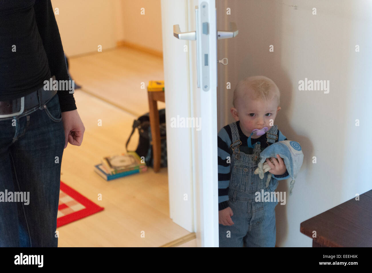 Freiburg im Breisgau, kleines Kind versteckt sich hinter einer Tür Stockfoto