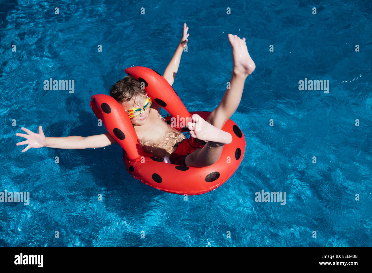 Kleiner Junge mit schwebenden Haltung zeigt in einem pool Stockfoto