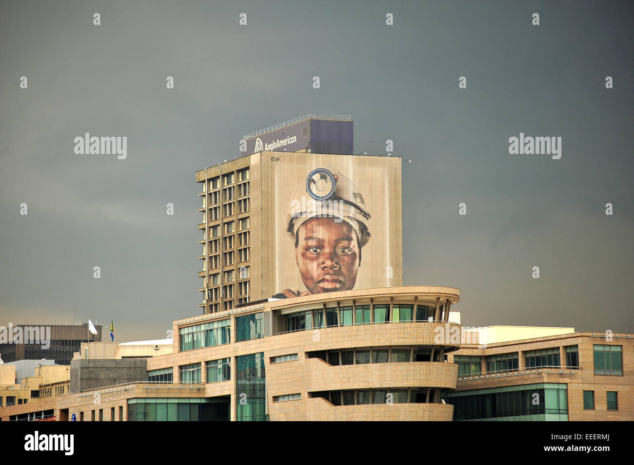 Aus der Ferne betrachtet ein Bergarbeiter-Gesicht auf einem Wolkenkratzer in Johannesburg Central Business District. Stockfoto