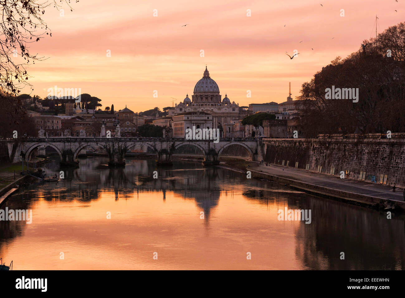 Roma, Hauptstadt Italiens. Die magische Atmosphäre des Sonnenuntergangs mit San Pietro in Vaticano, mit Blick auf den Tiber und seine Brücken. Stockfoto