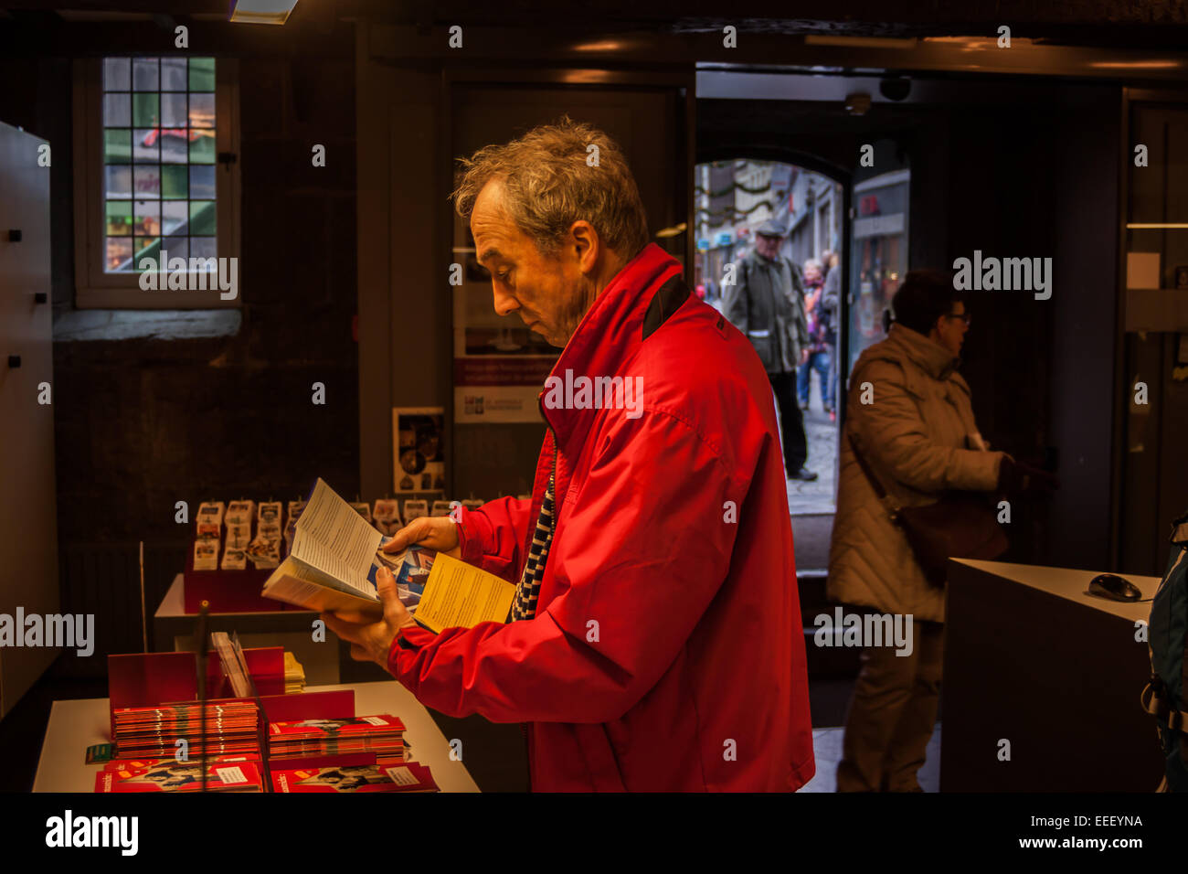 Ein Alter Mann liest eine Broschüre in der Filiale der VVV Touristeninformation in Maastricht, Limburg, Niederlande Stockfoto