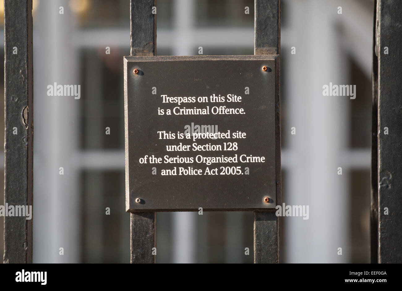 Ein Schild "Hausfriedensbruch auf dieser Seite ist eine strafbare Handlung" auf dem Zaun rund um Portcullis House, Westminster, London Stockfoto