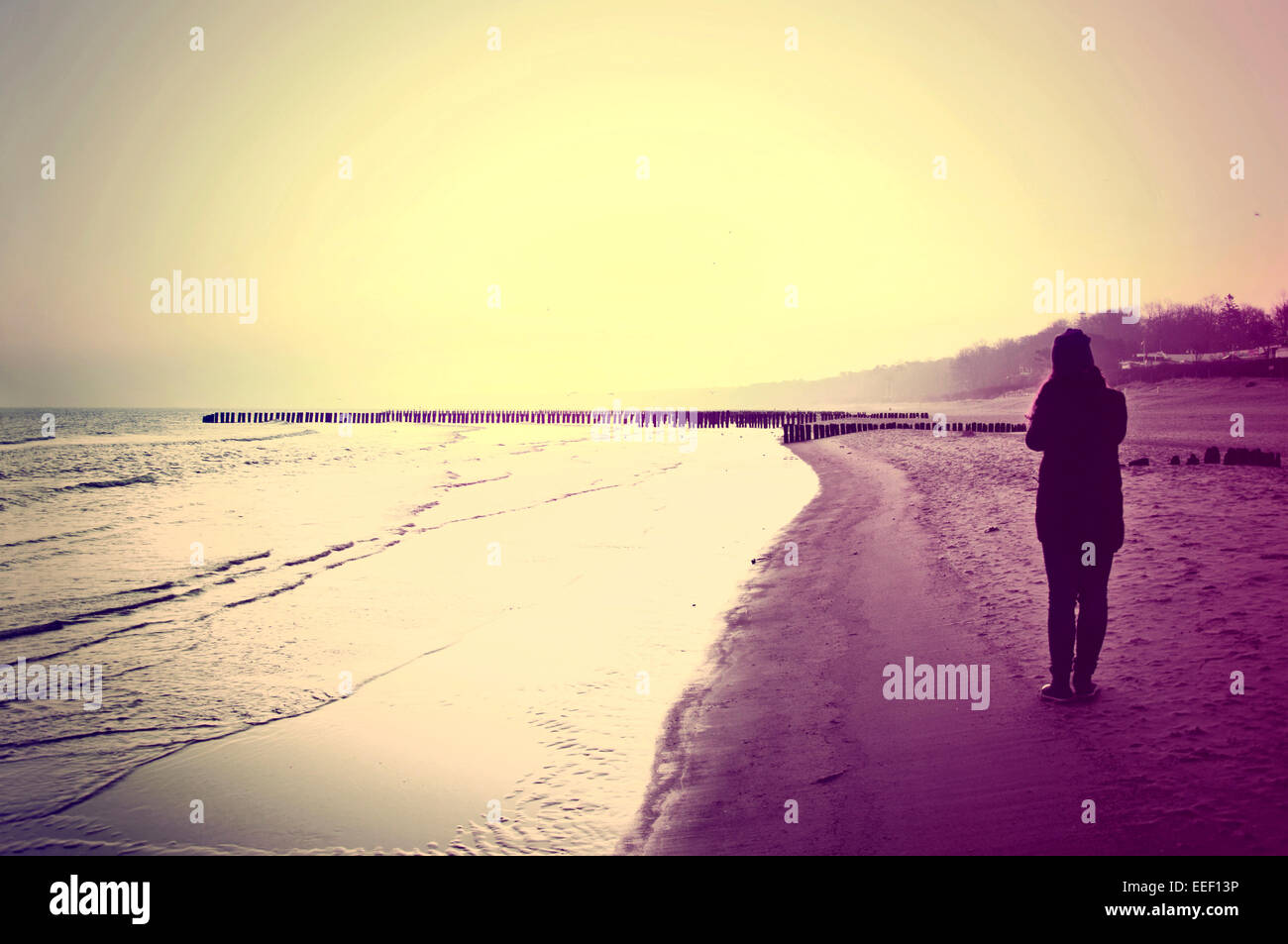 Emotion Konzeptbild. Einsame Frau zu Fuß am Strand. Instagram Vintage Bild. Stockfoto