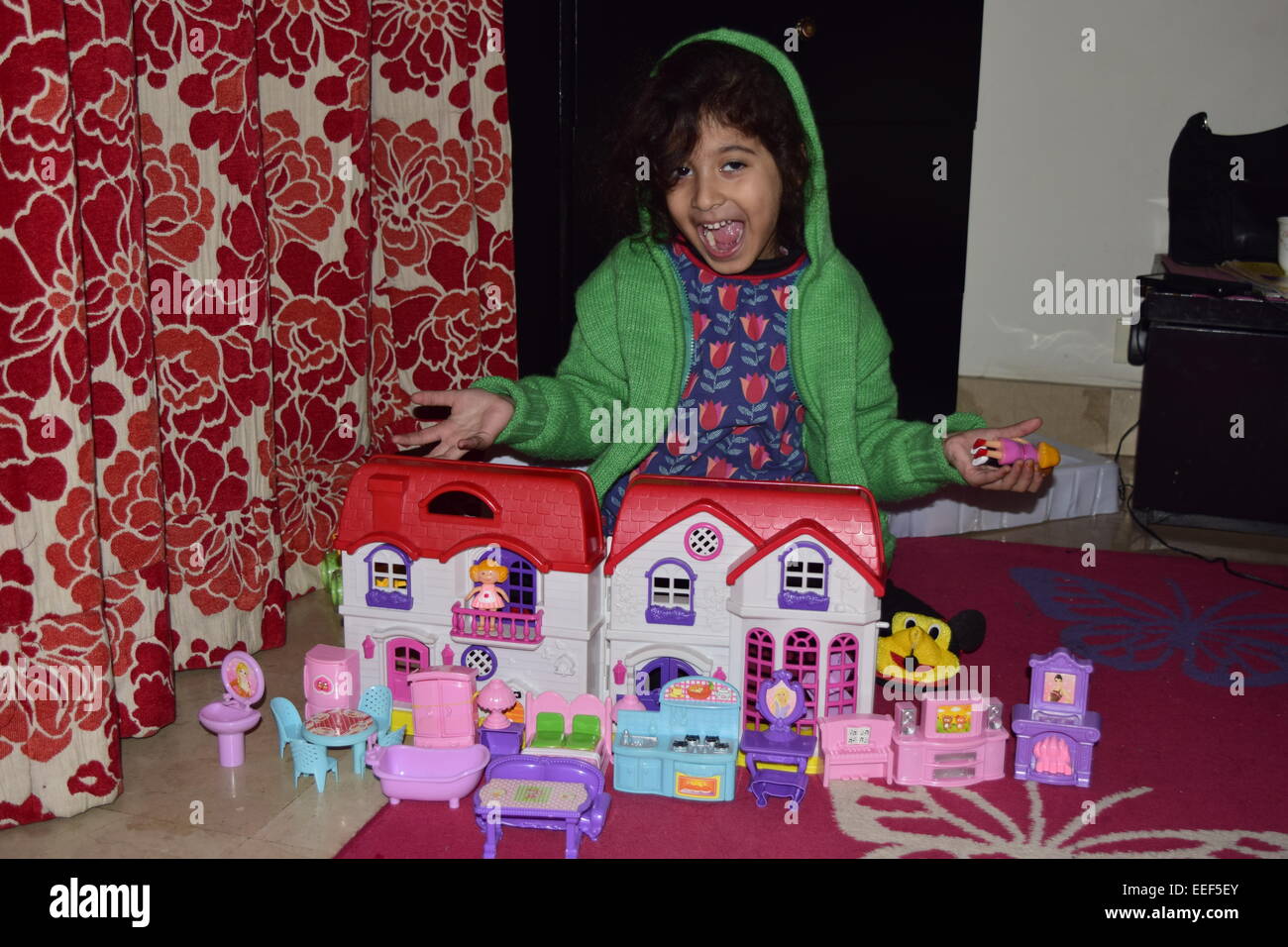 Kleine Mädchen spielen mit ihrem Puppenhaus Stockfoto