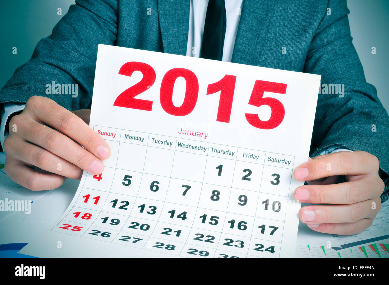 ein junger Geschäftsmann in seinem Büroschreibtisch zeigt einen Kalender 2015 Stockfoto