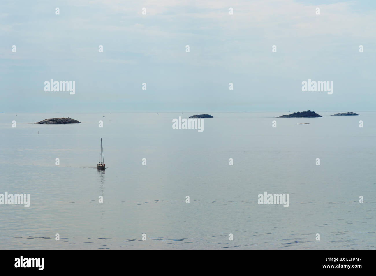 Einsame Yacht und Inseln im Meer Stockfoto