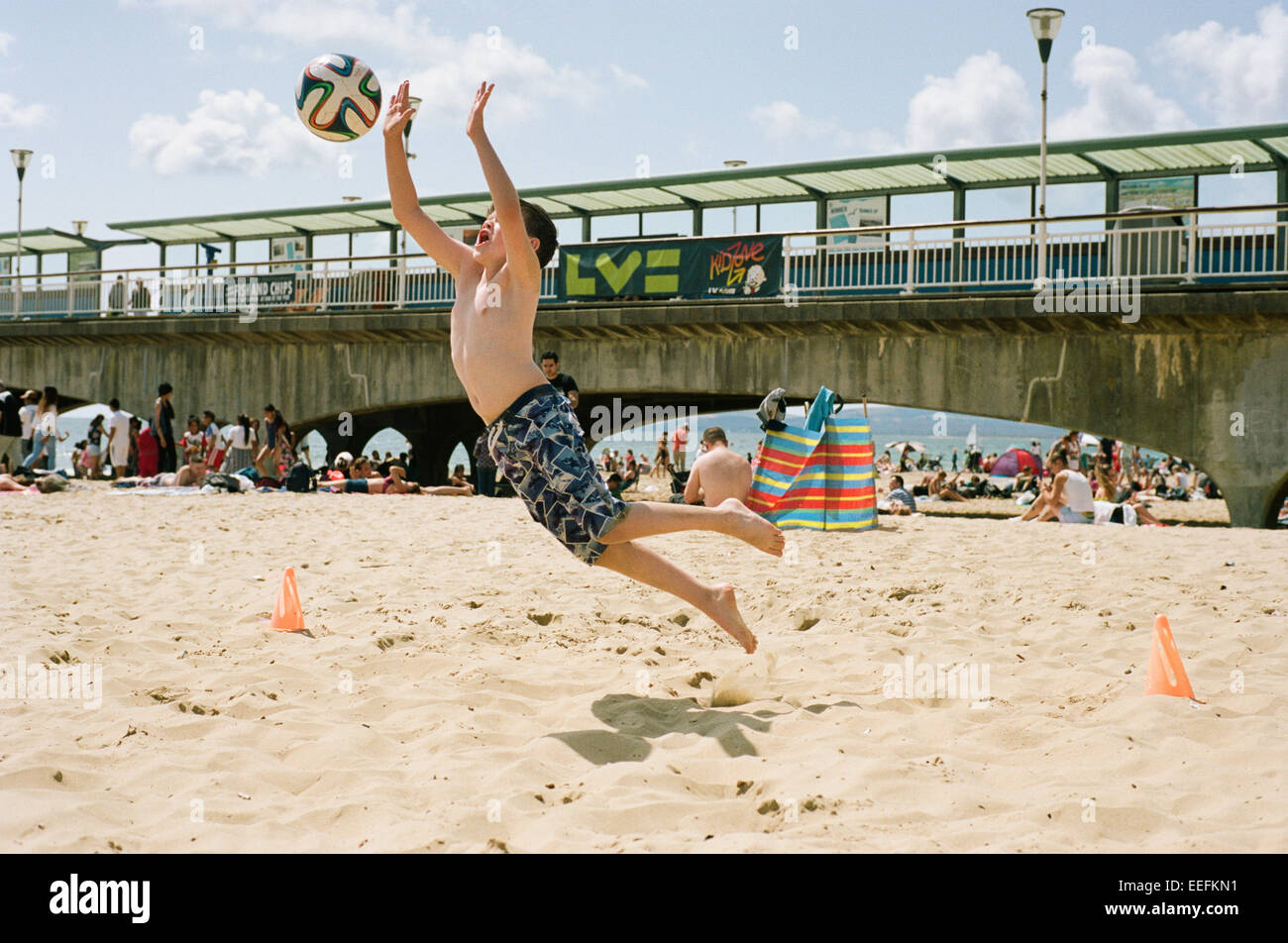 Junge macht groß sparen am Strand von Bournemouth, Sommerurlaub Stockfoto