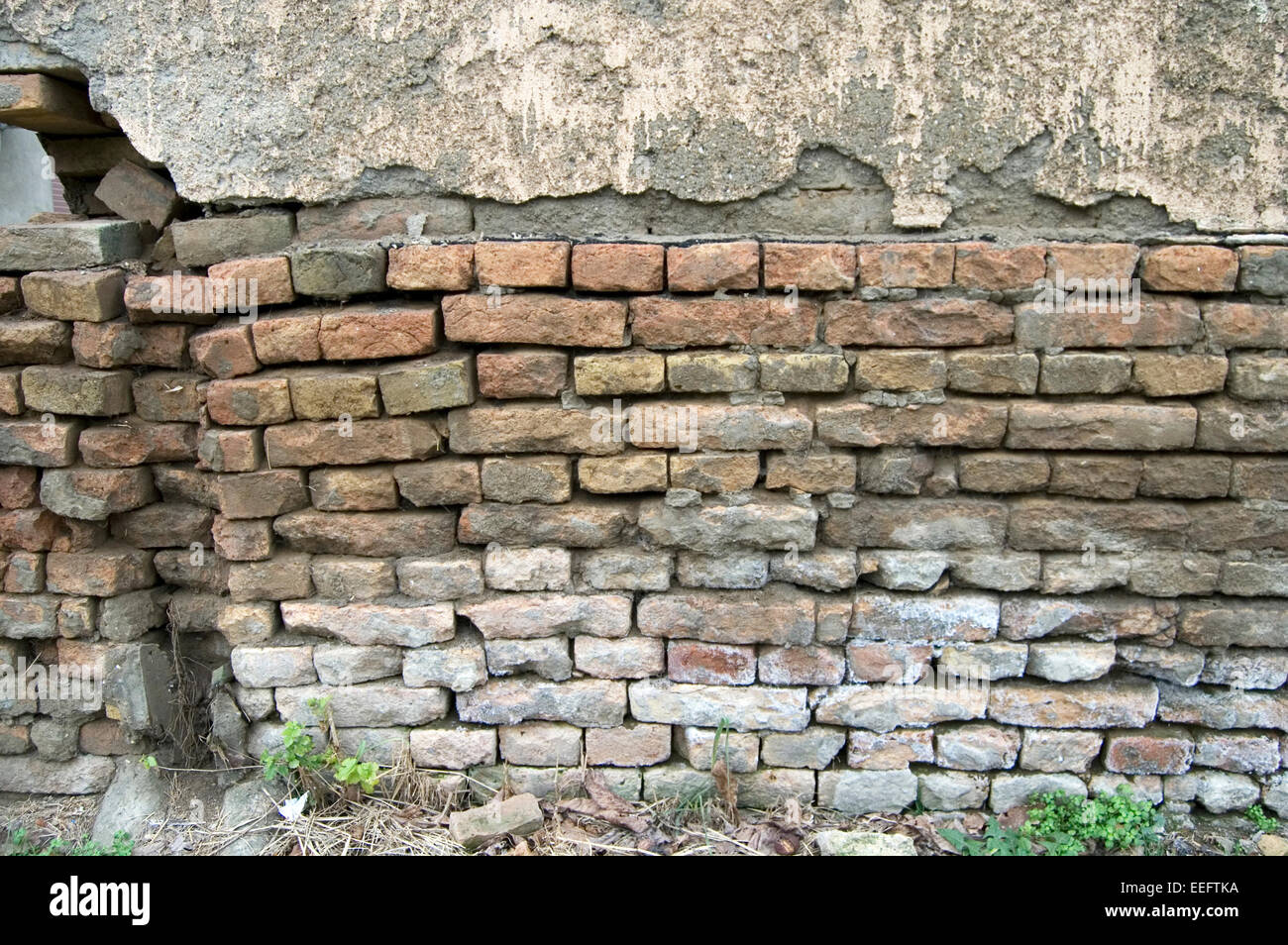 Die alte verfallene Mauer des Hauses, das baufällig ist. Stockfoto