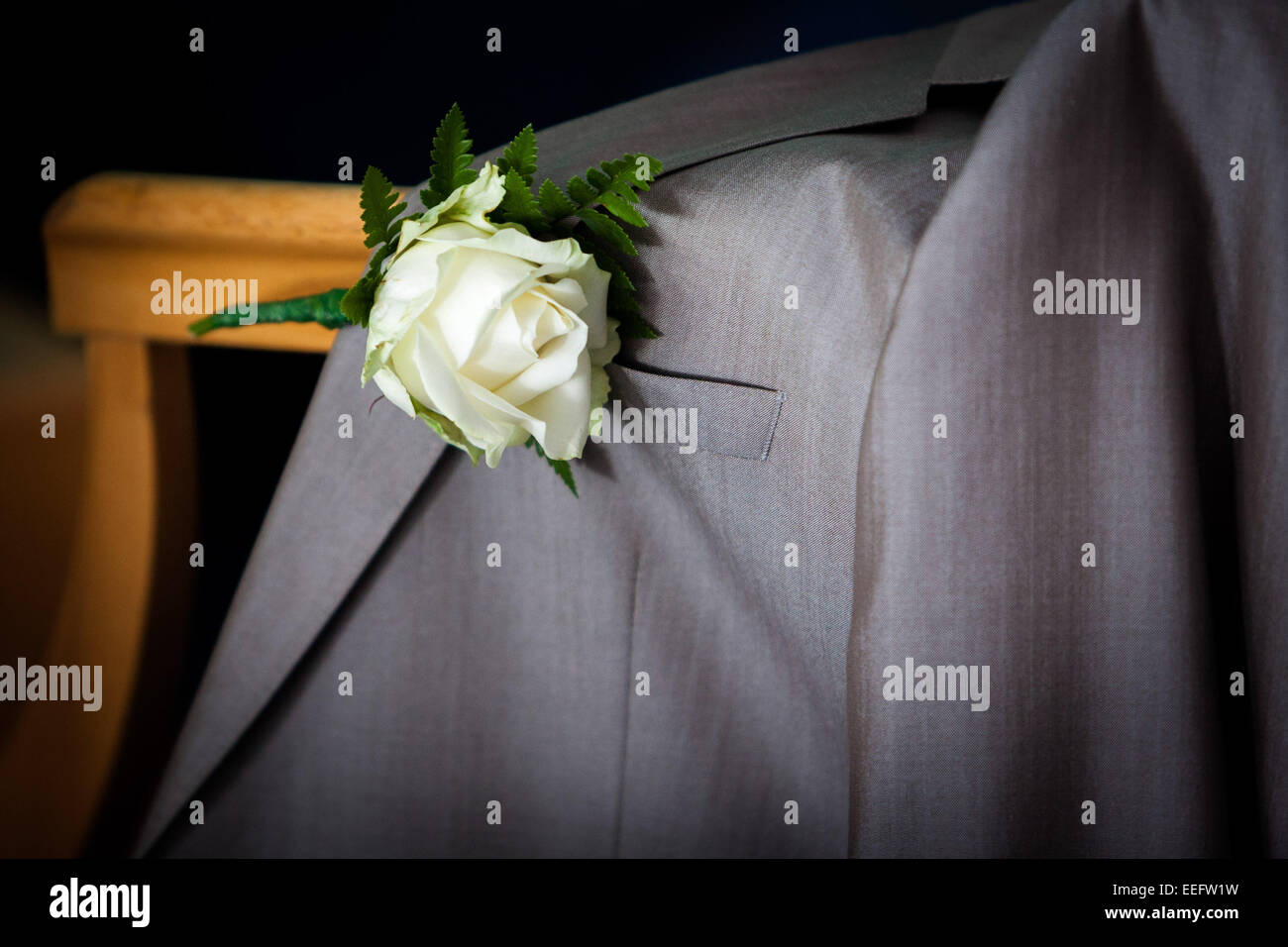 Nahaufnahme einer Schaltfläche Loch Blume auf einer Hochzeit Gäste Jacke Stockfoto