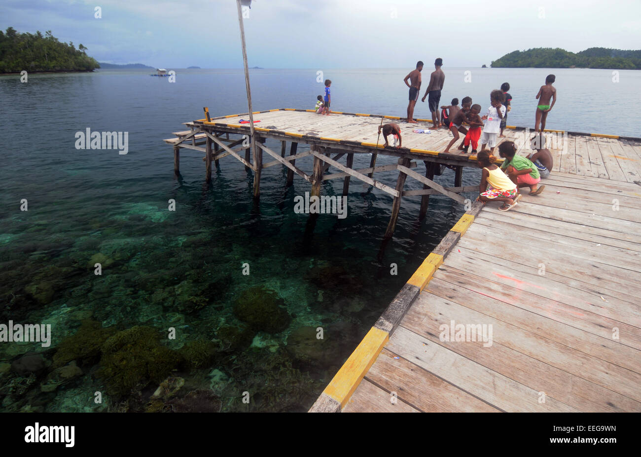 Kinder spielen und Angeln vom Steg, Yenbeser Dorf, Gam Insel, Raja Ampat, Provinz Papua, Indonesien. Weder Herr PR Stockfoto