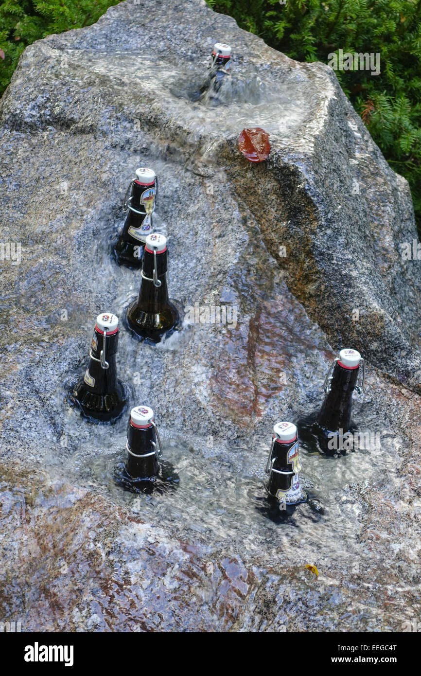 Bierflaschen Werden in Einem Gartenbrunnen aus Stein Gekühlt, Bier Flaschen gekühlt werden in einem Steinbrunnen, Brunnen, Fluss, fließt Stockfoto