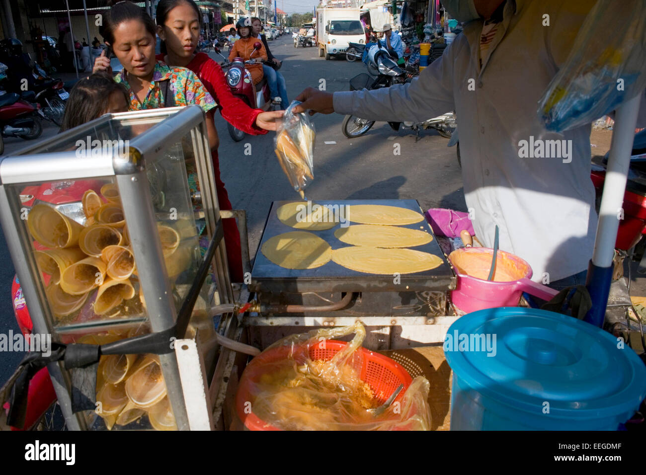 Ein Mann macht Roti, ein beliebtes street Food in Südostasien, auf einem mobilen Essen Wagen auf eine Stadt Straße in Kampong Cham, Kambodscha. Stockfoto