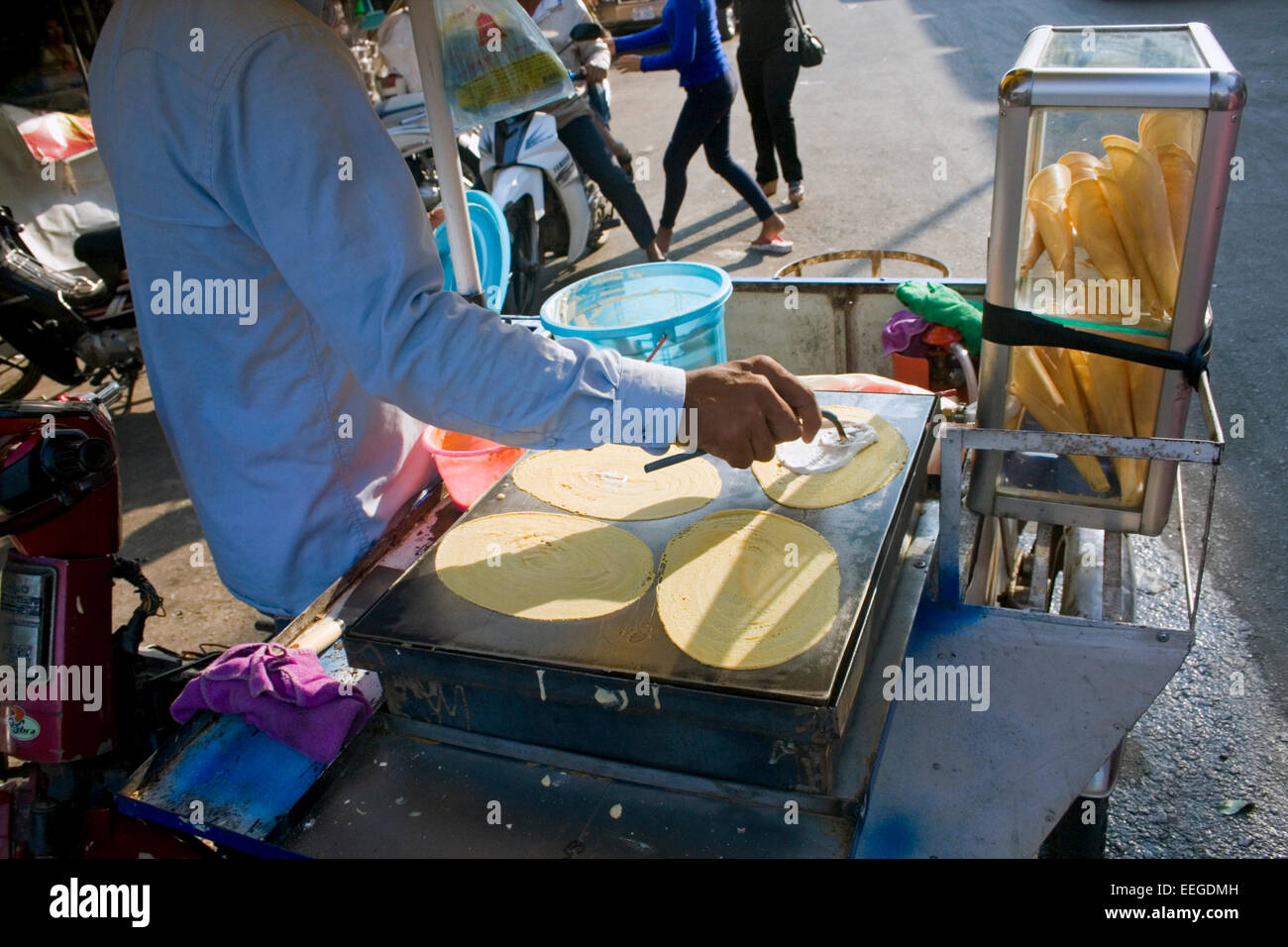 Ein Mann macht Roti, ein beliebtes street Food in Südostasien, auf einem mobilen Essen Wagen auf eine Stadt Straße in Kampong Cham, Kambodscha. Stockfoto