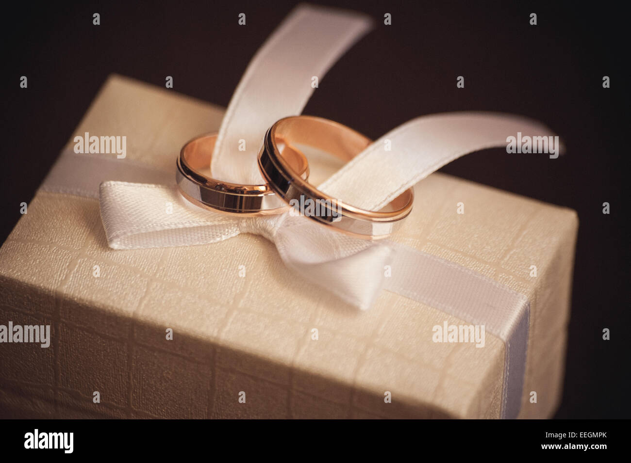 zwei Trauringe auf weißer Schleife platziert Stockfoto