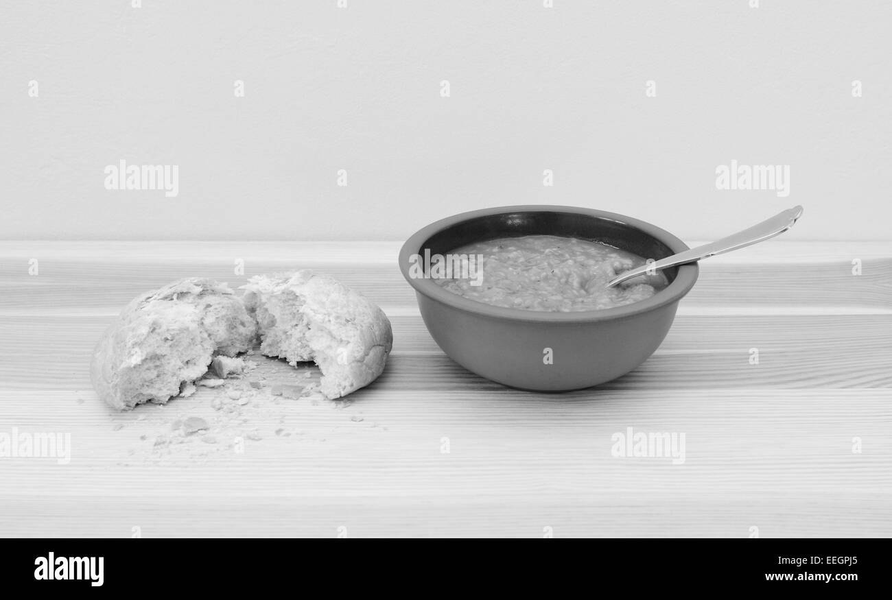 Schale mit leckeren Gemüsesuppe mit einem Brot Rollen zerrissen in halb - monochrome Verarbeitung Stockfoto
