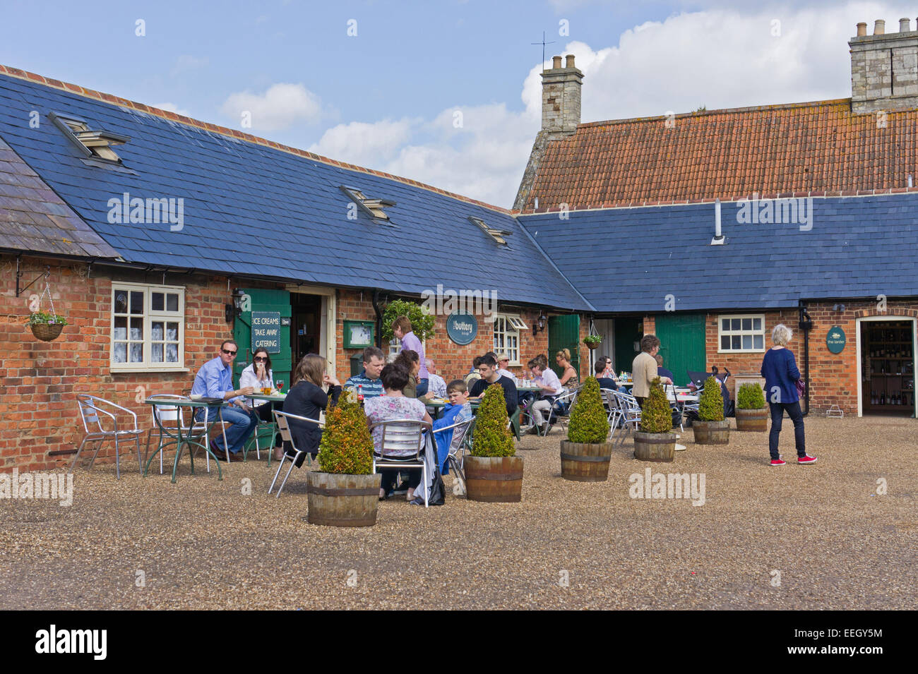 Das Café im Schloss Ashby Shopping Hof, Kunden bei Außengastronomie genießen die warme Sonnenstrahlen. Stockfoto