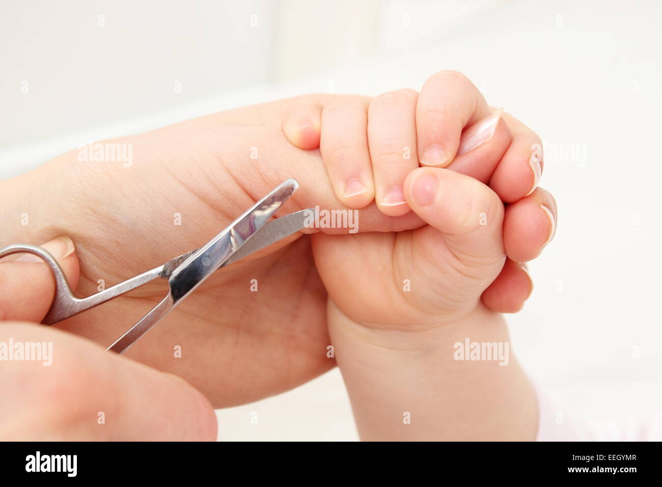 Eine Mutter schneidet Fingernägel eines Babys Stockfoto