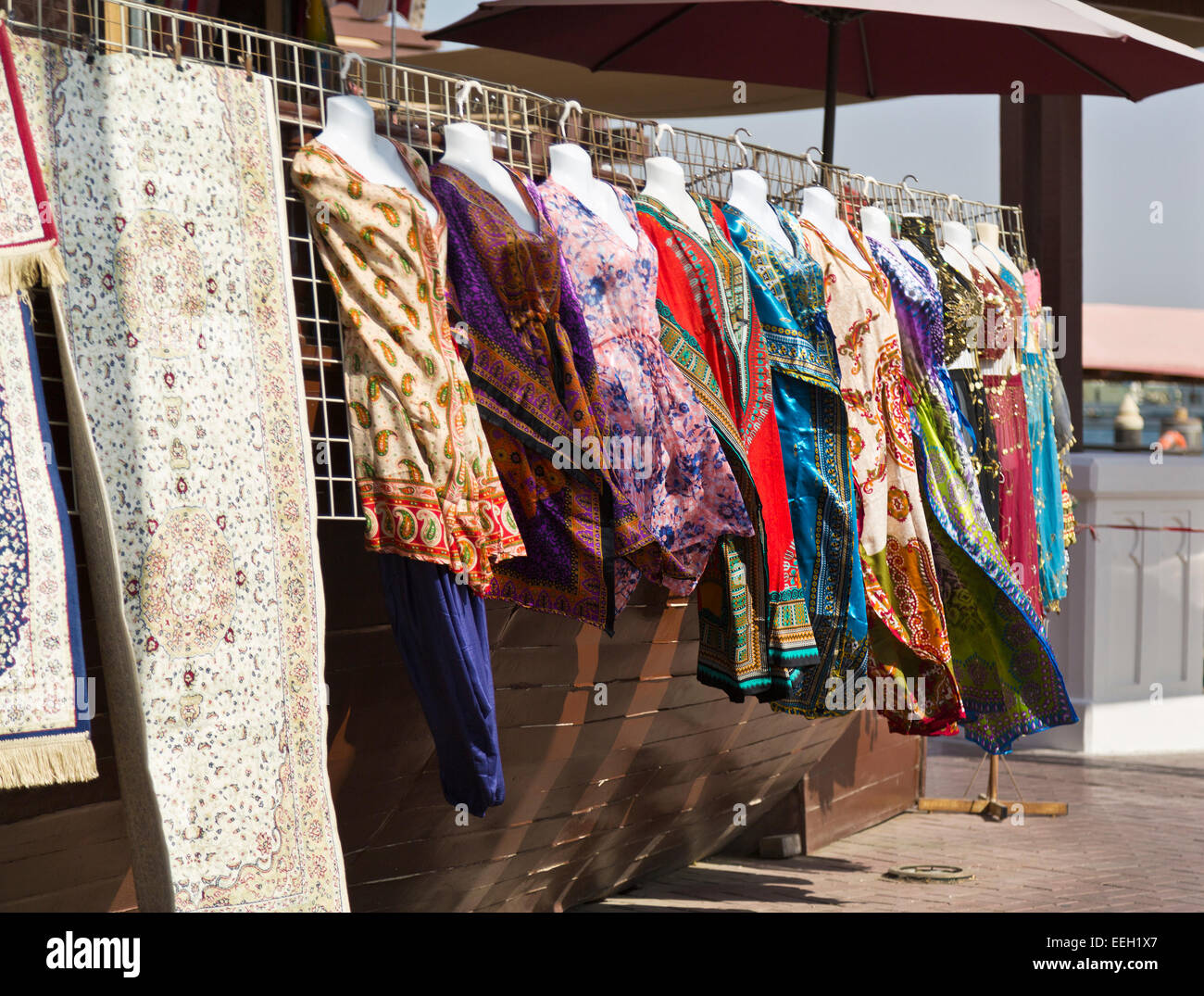 Frauen Kleidung und Teppiche zum Verkauf am Dubai Creek, Dubai, Vereinigte Arabische Emirate Stockfoto
