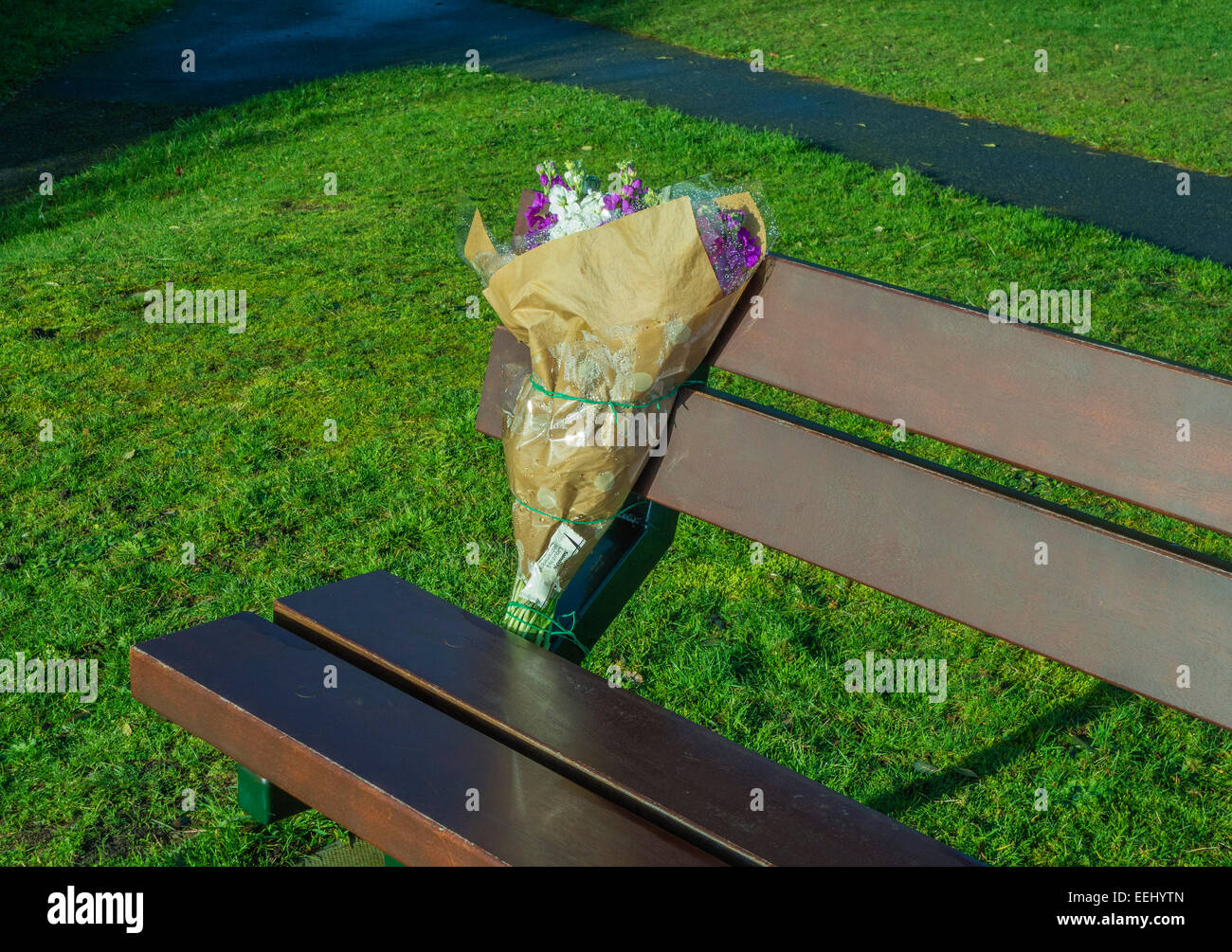 Blumen auf dem Sitz in der Erinnerung an Freund oder Verwandten, England, UK. Stockfoto