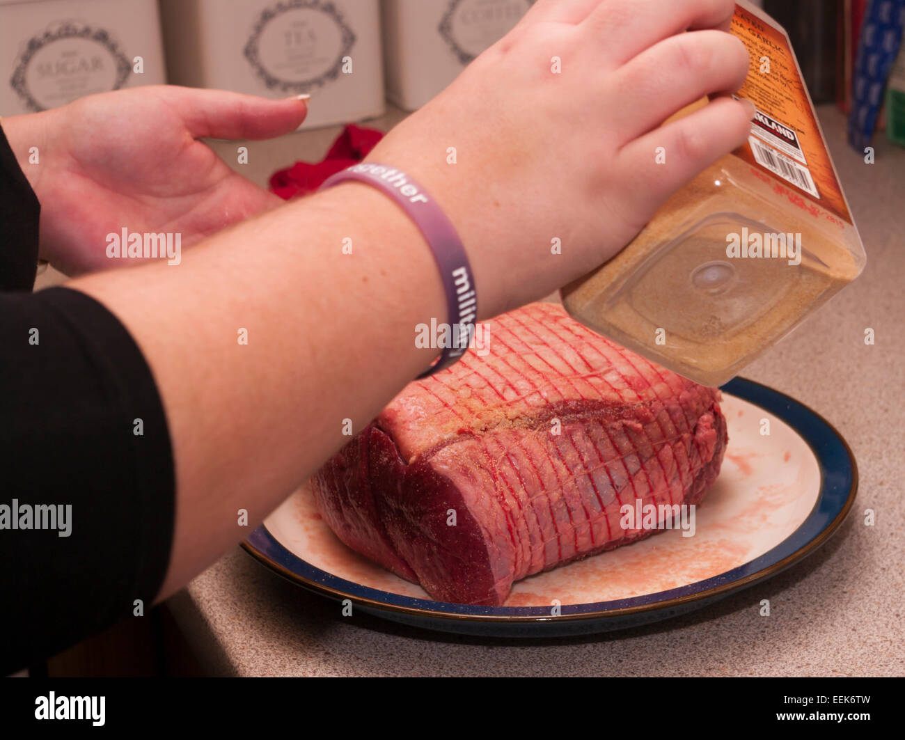 Frau eine Fuge von Rindfleisch würzen Stockfoto