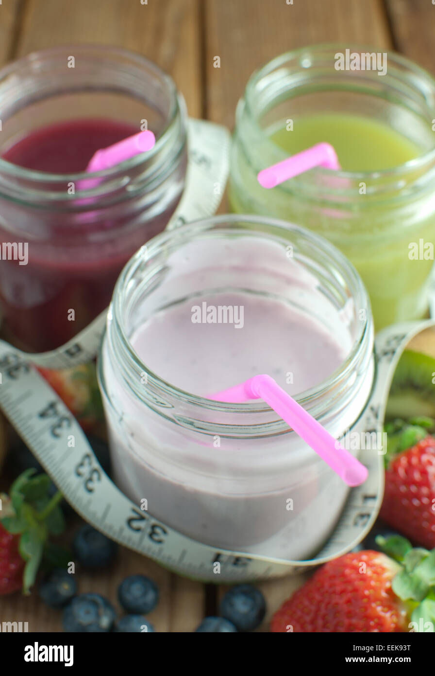 Drei aromatisierte Smoothies in Gläsern mit Früchten Stockfoto