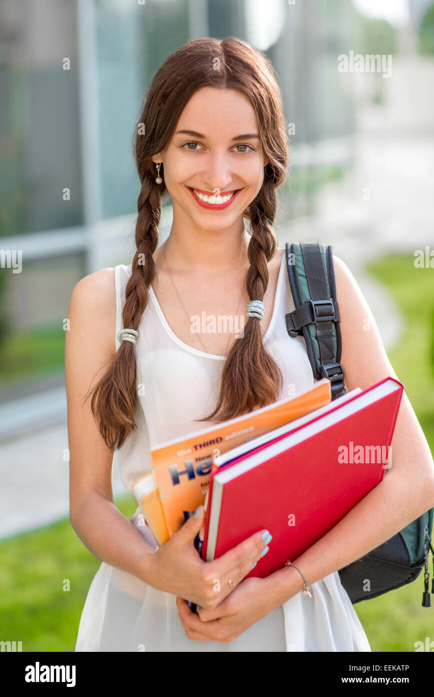Studentin im Freien mit Rucksack und Bücher zur Schule zu gehen und lächelnd Stockfoto