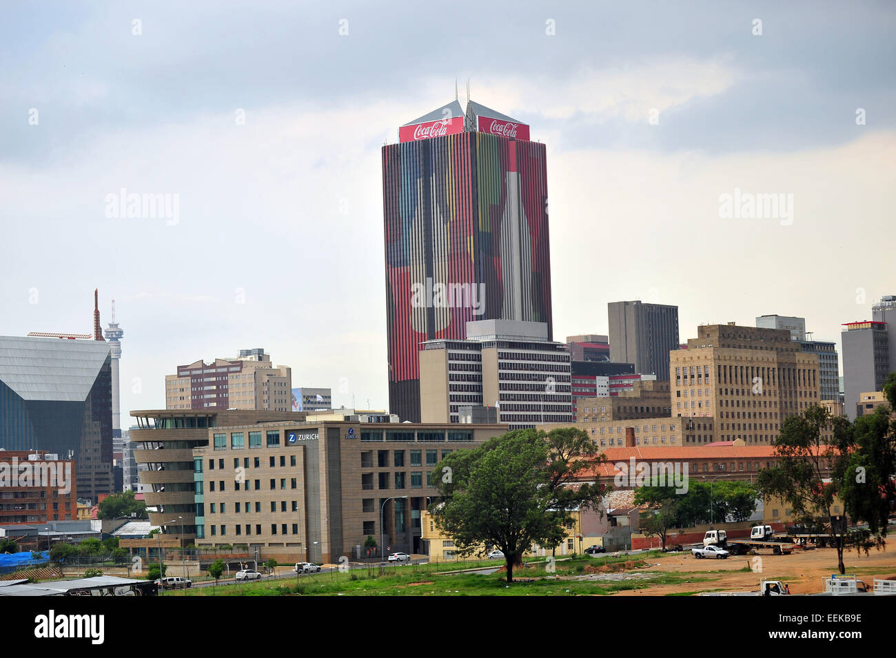 Aus der Ferne betrachtet ein Coca Cola bedeckt Wolkenkratzer in Johannesburg Central Business District. Stockfoto