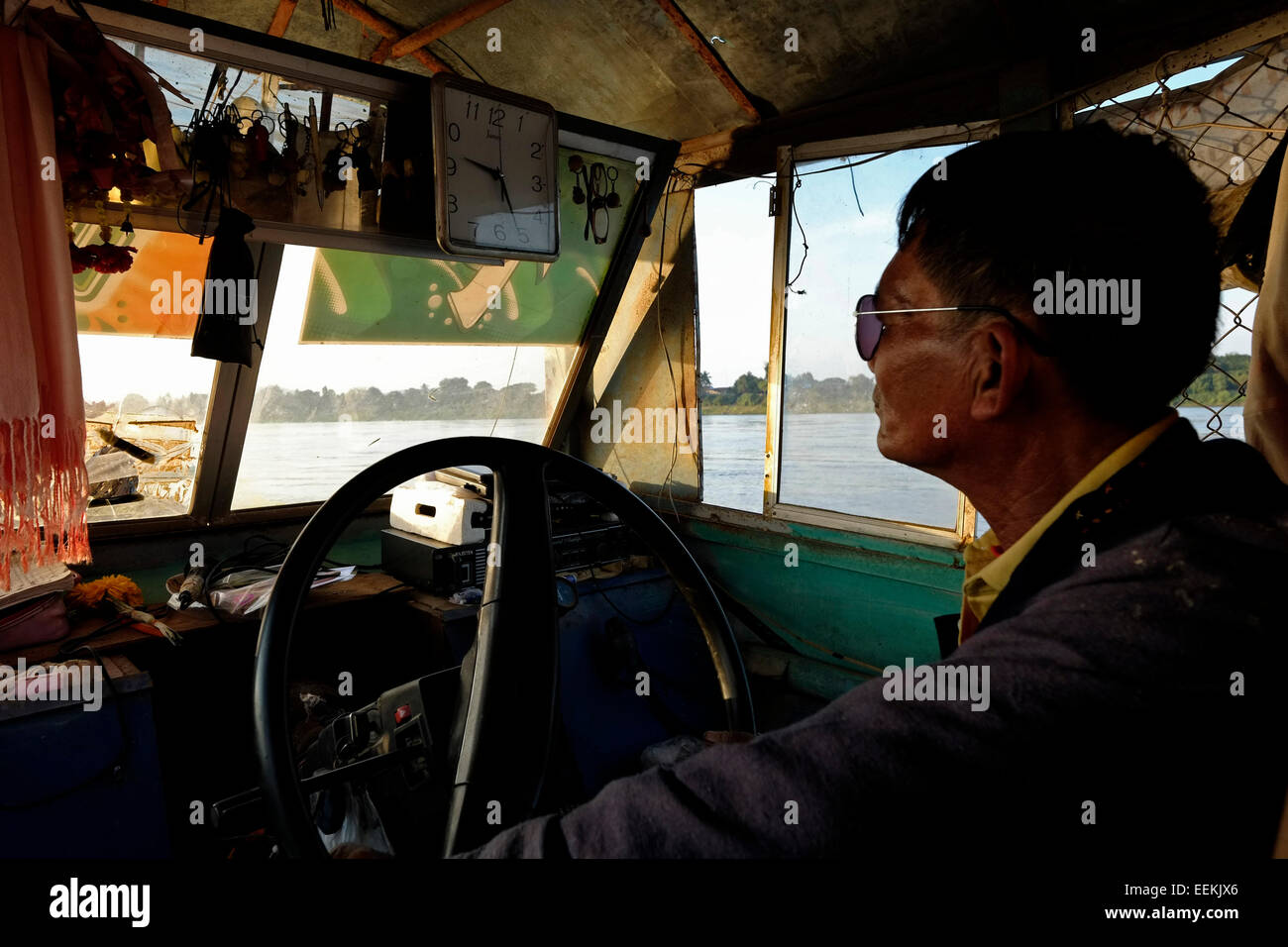 Ein Thailänder, der mit einem langsamen Boot den Mekong entlang im Bezirk Chiang Khan in der Provinz Loei nordöstlich von Thailand an der Grenze zu Laos fährt Stockfoto
