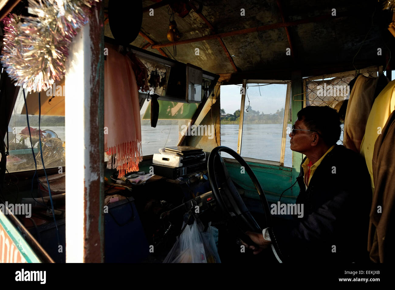 Ein Thailänder, der mit einem langsamen Boot den Mekong entlang im Bezirk Chiang Khan in der Provinz Loei nordöstlich von Thailand an der Grenze zu Laos fährt Stockfoto