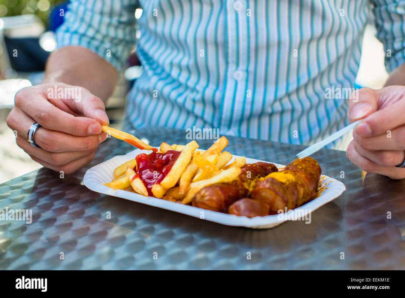 Menschen Sie essen Deutsche Currywurst am stand Stockfoto