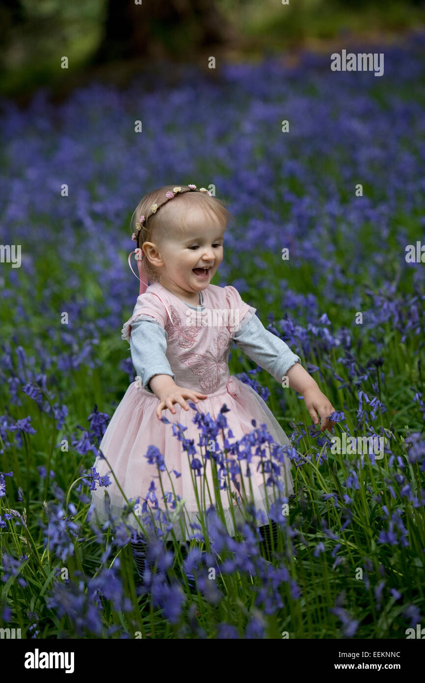 Glückliches Mädchen Lachen in einem Holz voller Glockenblumen in England. Stockfoto