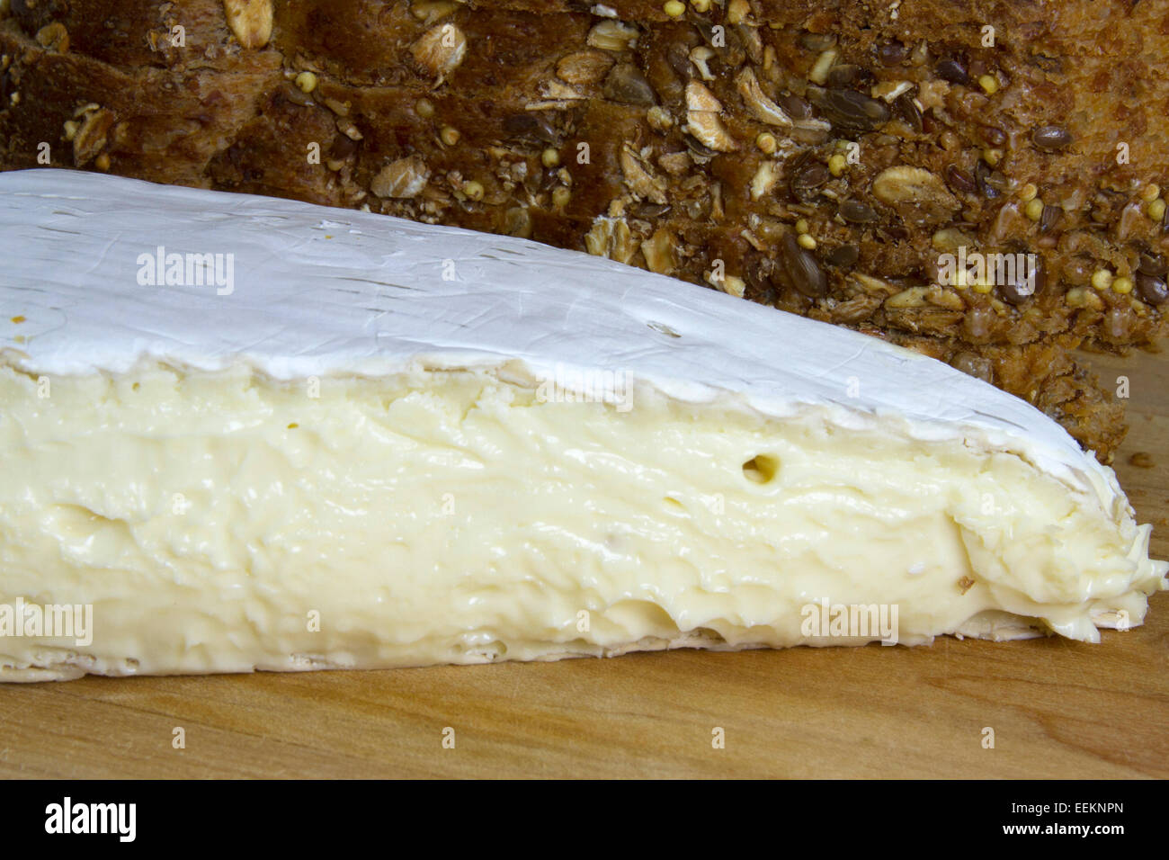 Keil Brie Käse auf Holzbrett mit Vollkorn Brot Stockfoto