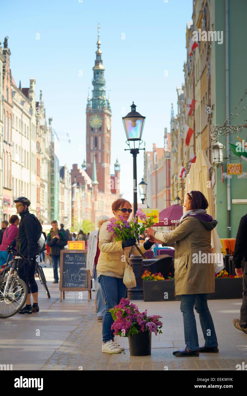 Danzig Polen. Blumenverkäuferin auf Haupteinkaufsstraße der Dluga im Herzen der Altstadt. Turm des Rathauses Main hinter Stockfoto