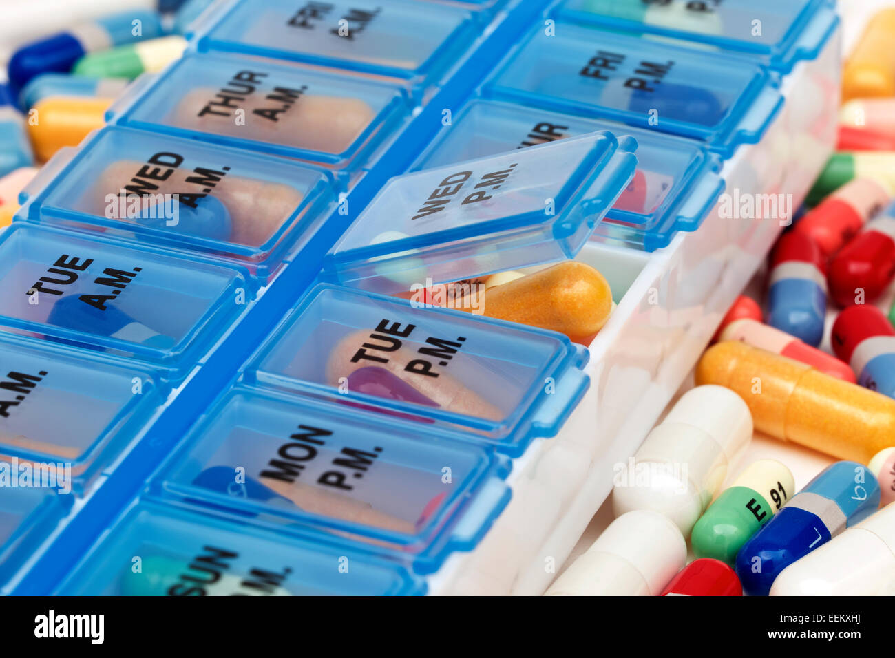 Vielzahl von Pillen und Vitamine in Haufen neben einer Pille-Veranstalter Stockfoto