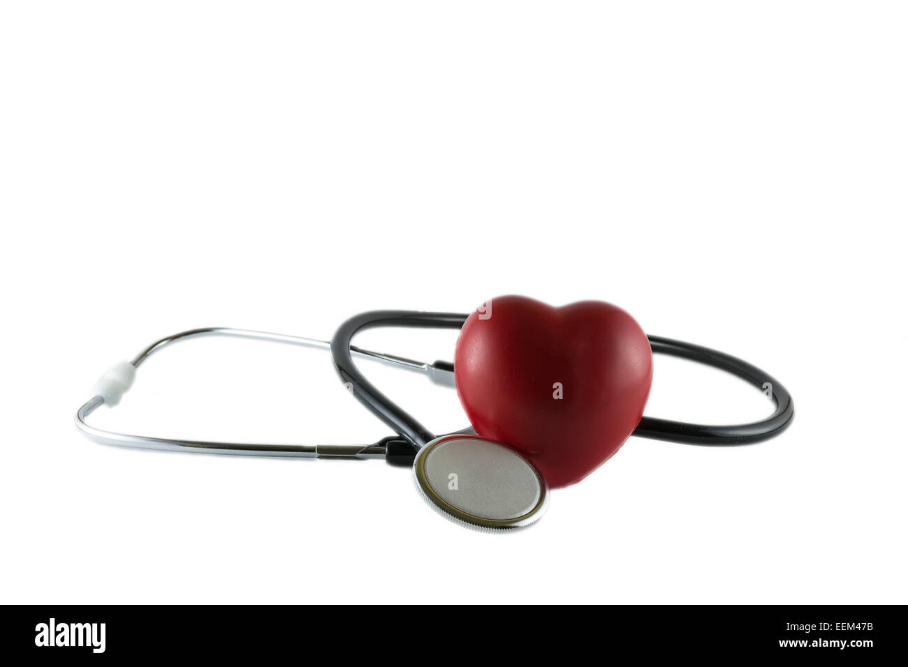 Herz neben dem Stethoskop in einer ärztlichen Beratung, isoliert auf weißem Hintergrund Stockfoto