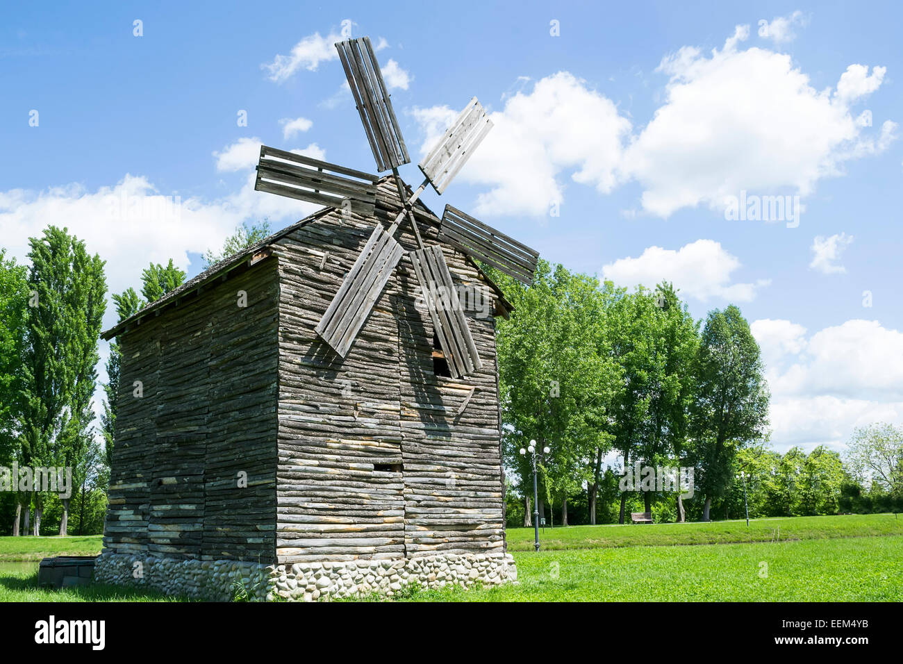 Alte hölzerne Windmühle mit Steinfundament wird auf dem Display in einem park Stockfoto
