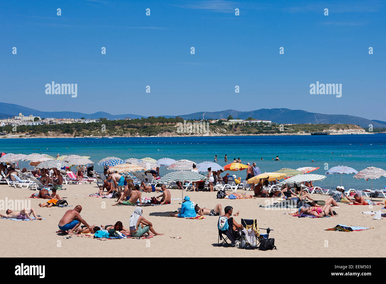 Menschen beim Sonnenbaden auf dem öffentlichen Strand. Didim, Provinz Aydin, Türkei. Stockfoto