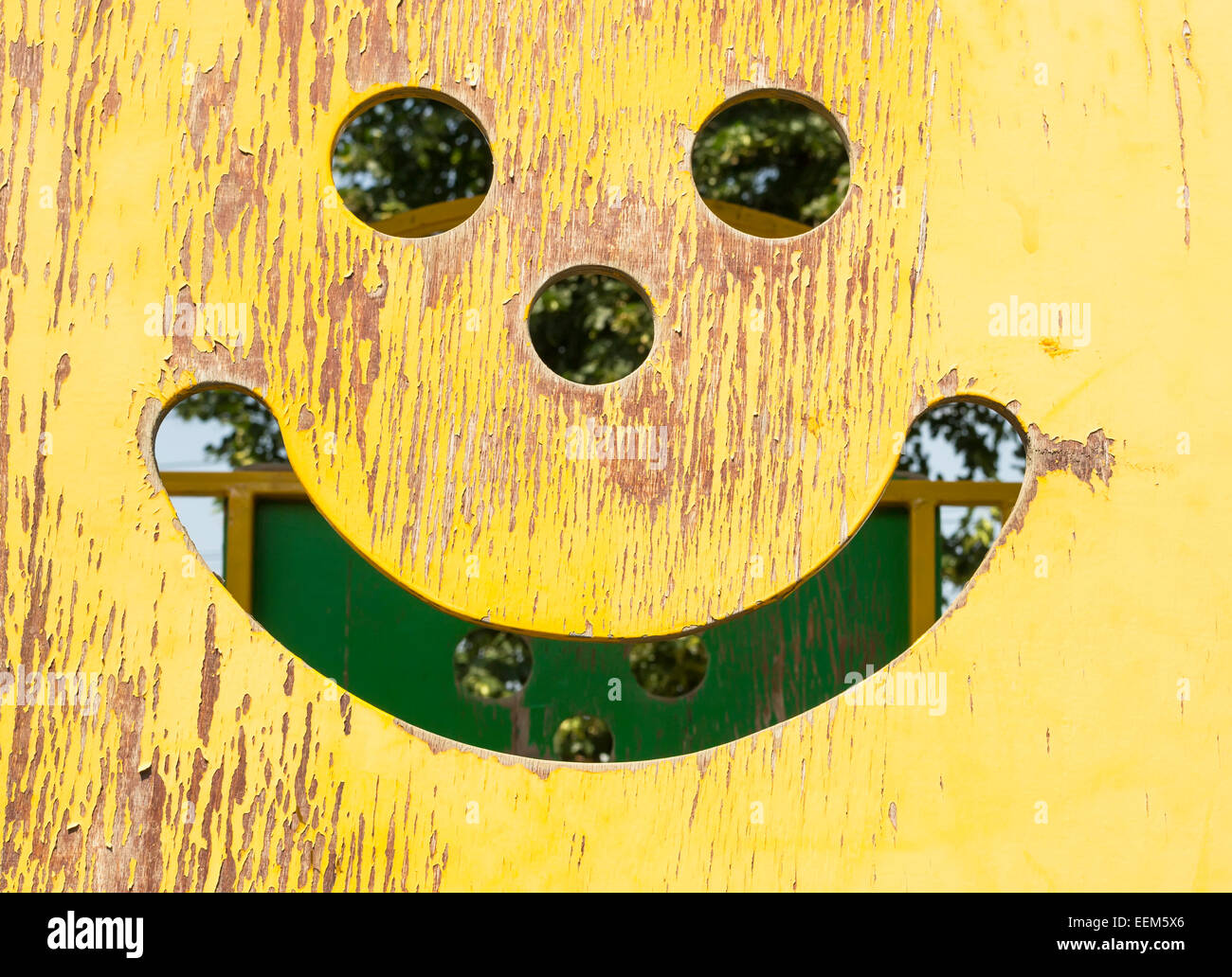 Smiley-Gesicht geschnitzt aus einem Stück Sperrholz auf Spielplatz Stockfoto