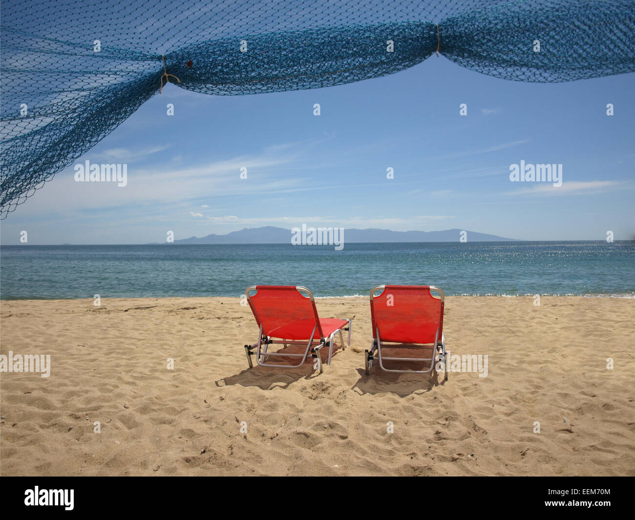 Griechenland, Thassos, rote Liegestühle am Strand Stockfoto