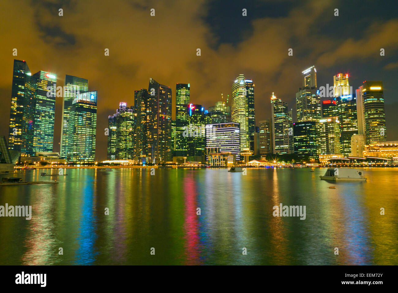 Skyline am Wasser mit beleuchteten Wolkenkratzern vom Hafen in Singapur aus gesehen Stockfoto