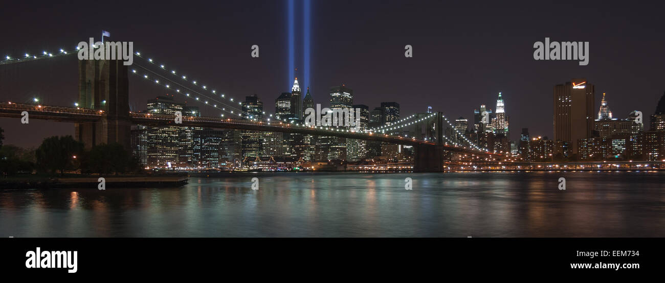 USA, New York, New York City, beleuchtete Skyline mit Brooklyn Bridge blaue Lichtstrahlen Stockfoto