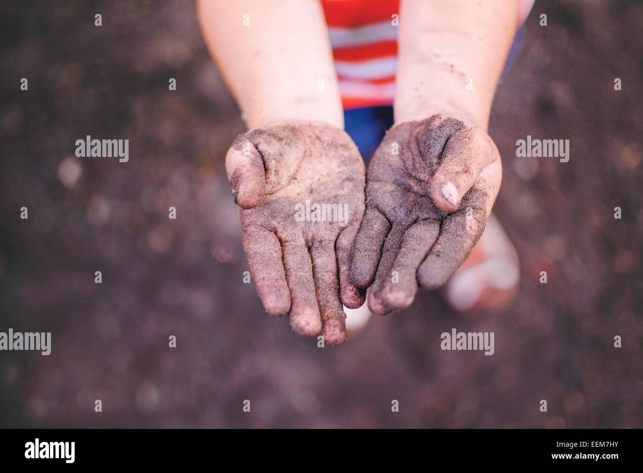 Ansicht von oben eines Jungen, der seine schmutzigen Hände zeigt Stockfoto