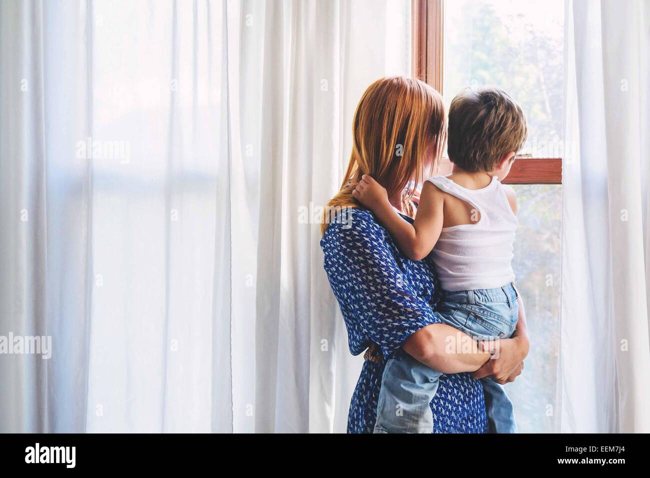 Mutter und ihr Sohn und Blick durch ein Fenster Stockfoto