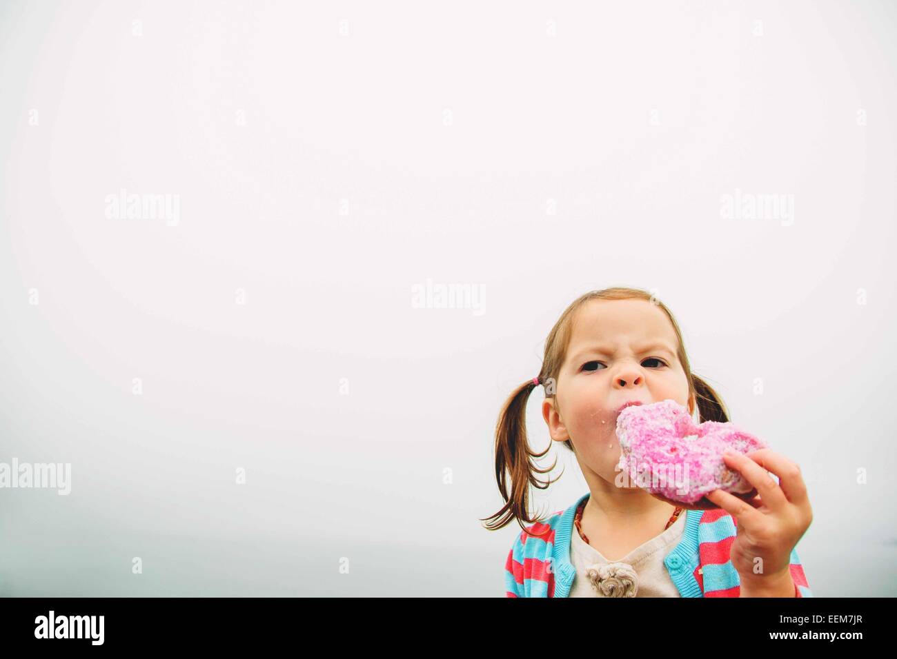 Porträt eines Mädchens, das einen Donut isst Stockfoto