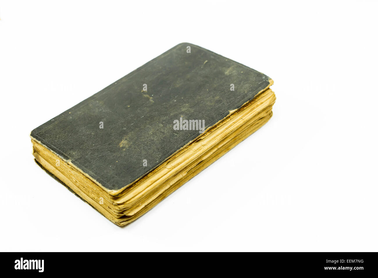 Altes Buch mit schwarzen Abdeckungen geschlossen und getragen von gelbeseiten, isoliert auf weiss Stockfoto