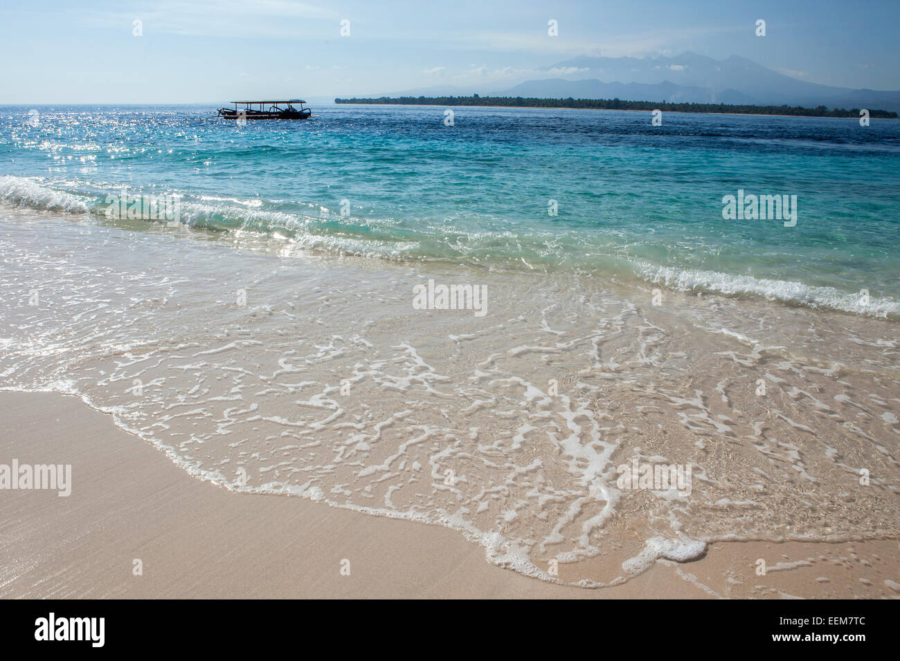 Indonesien, blaues Meer, weiße Surf mit Boot am Horizont Stockfoto